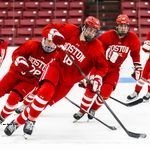 Photo: A group of hockey players on the ice skating to the right